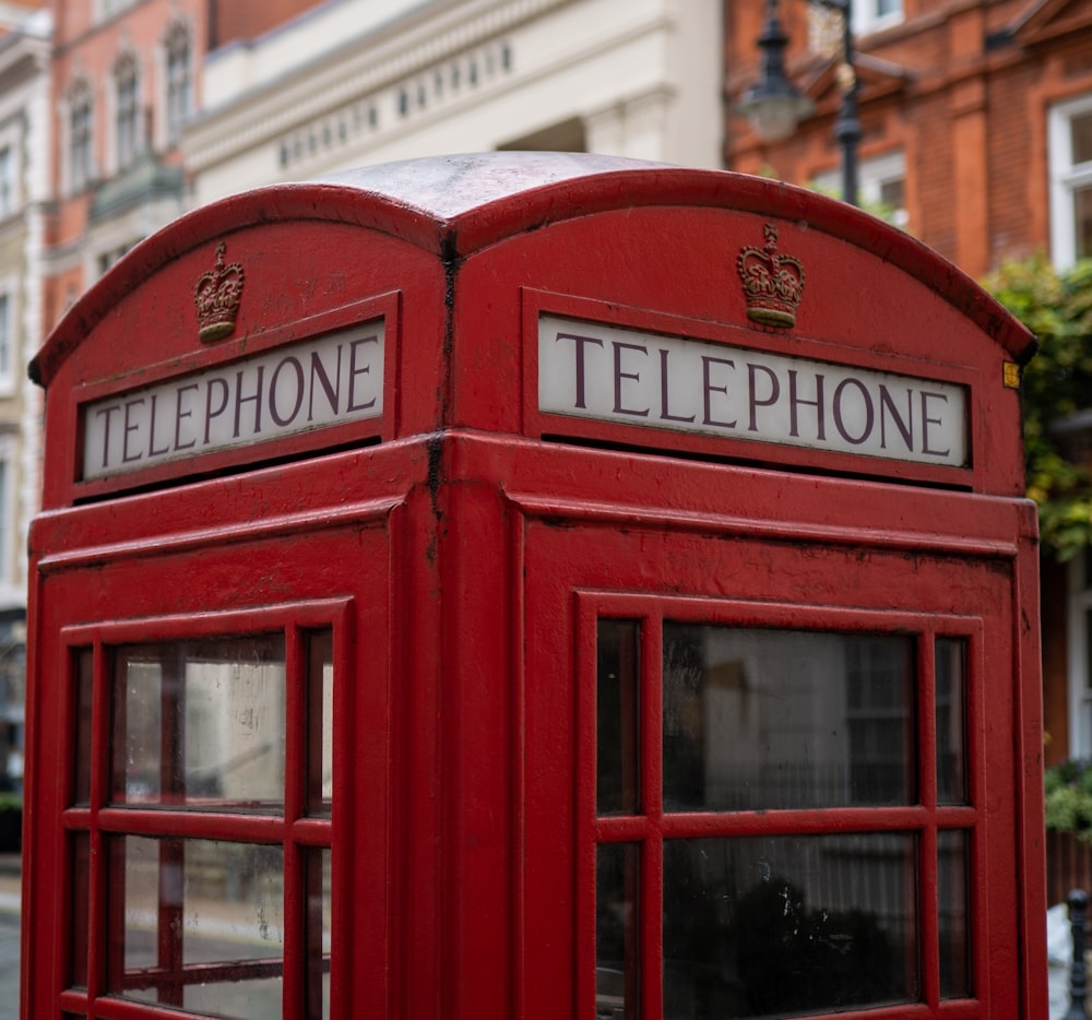 red telephone booth near building during daytime