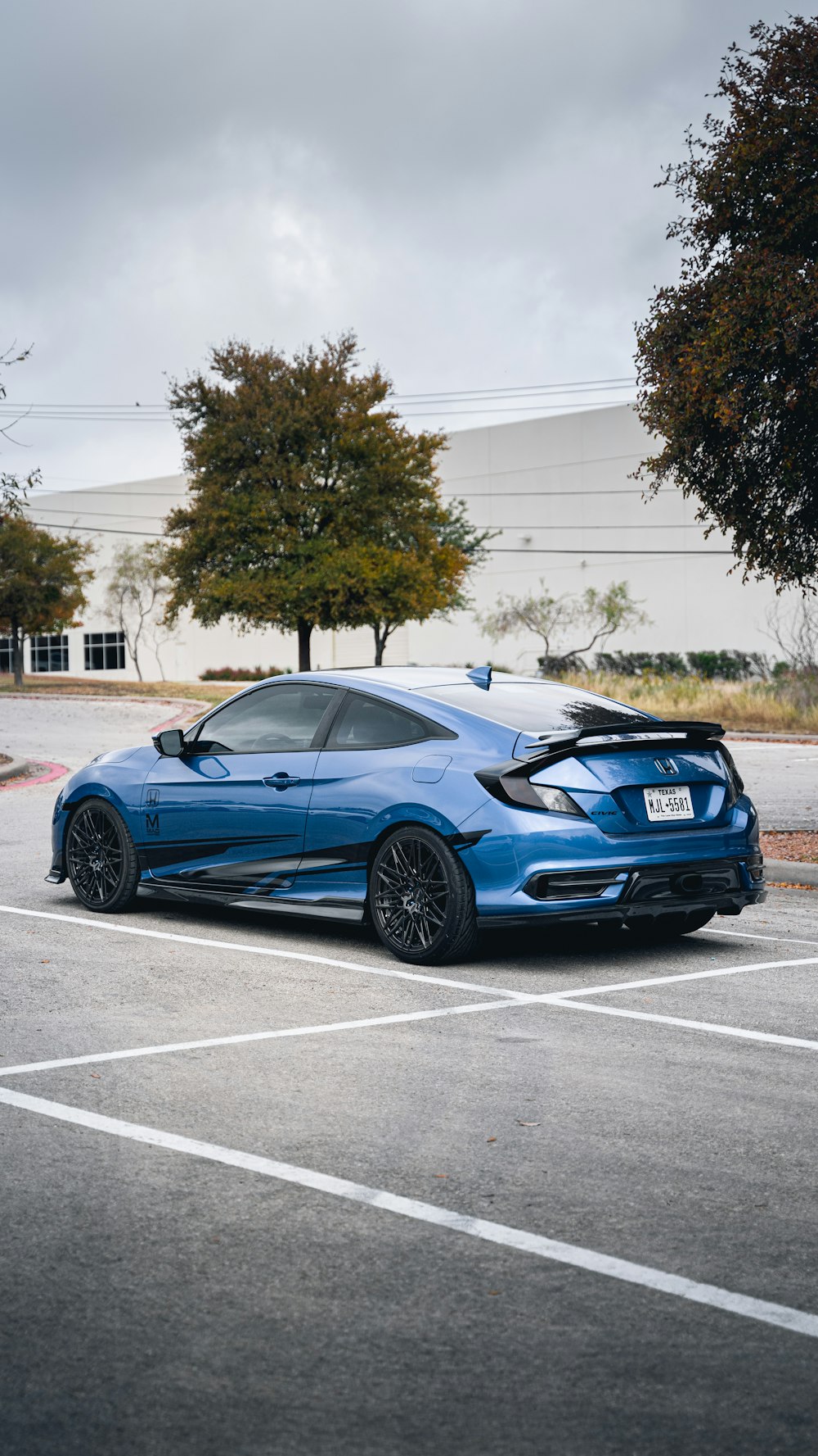 blue porsche 911 parked on gray concrete road during daytime