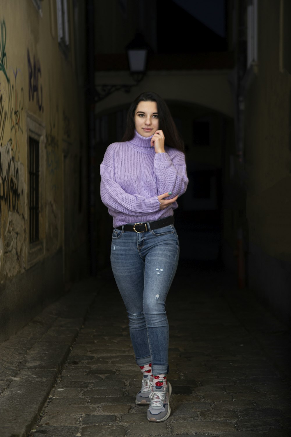woman in purple sweater and blue denim jeans standing on hallway