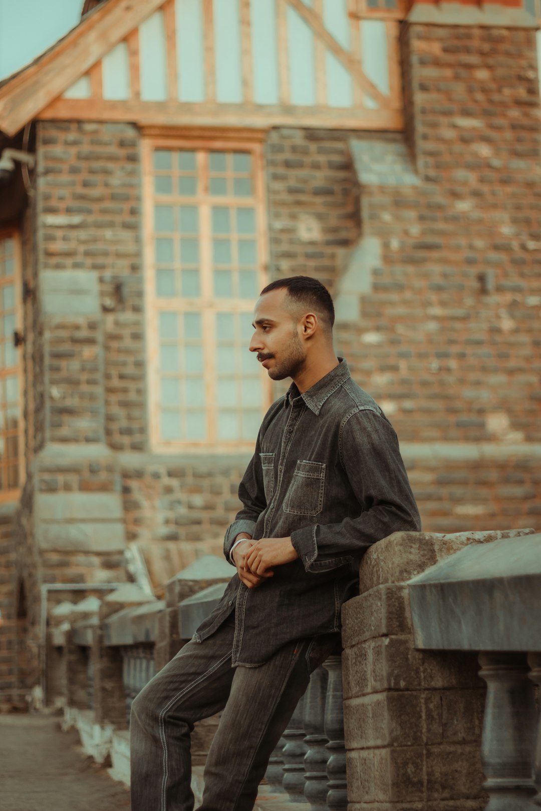 man in black dress shirt sitting on concrete bench