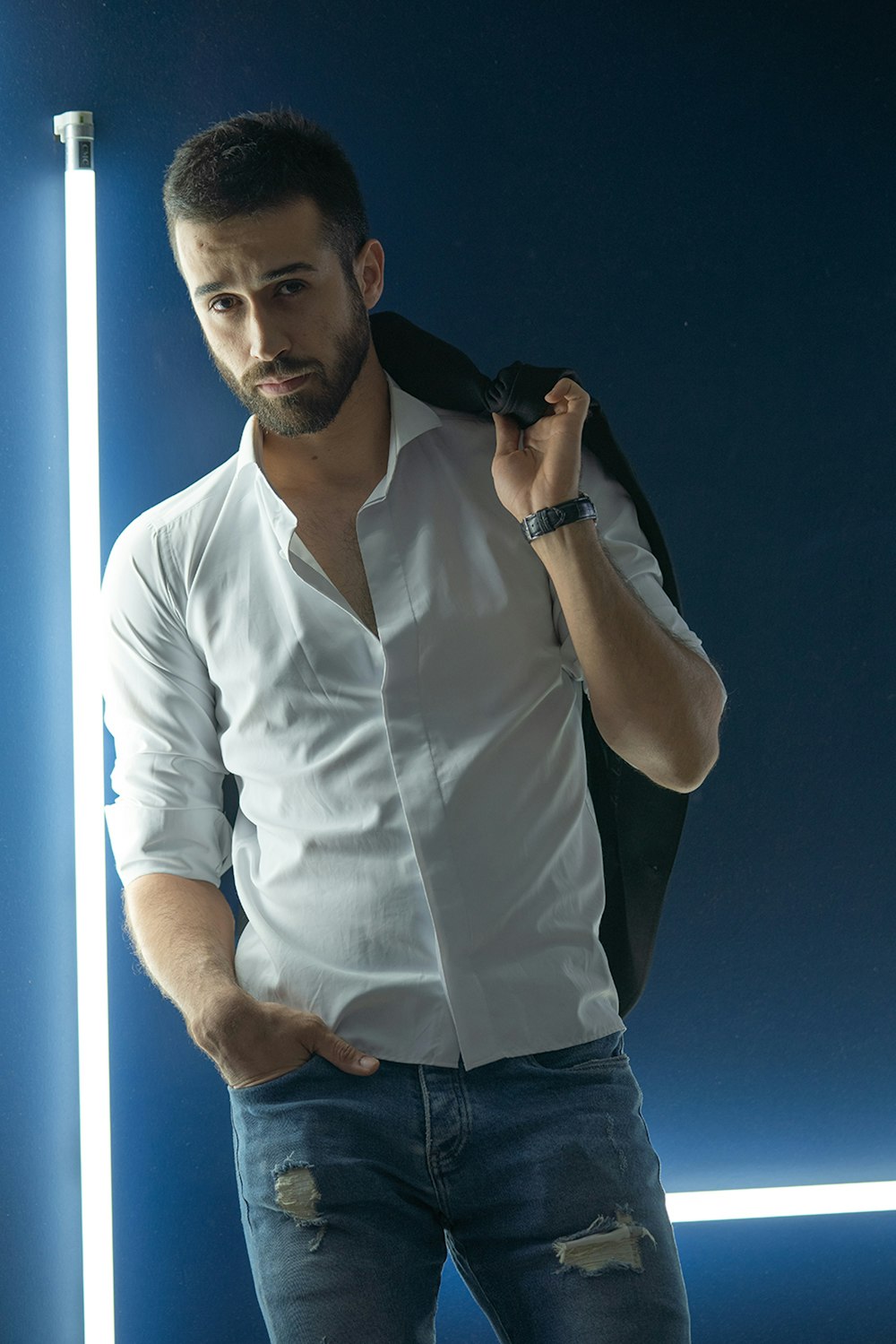Foto Hombre con camisa de vestir blanca y jeans de mezclilla azul  sosteniendo un teléfono inteligente negro – Imagen Provincia de teherán  gratis en Unsplash
