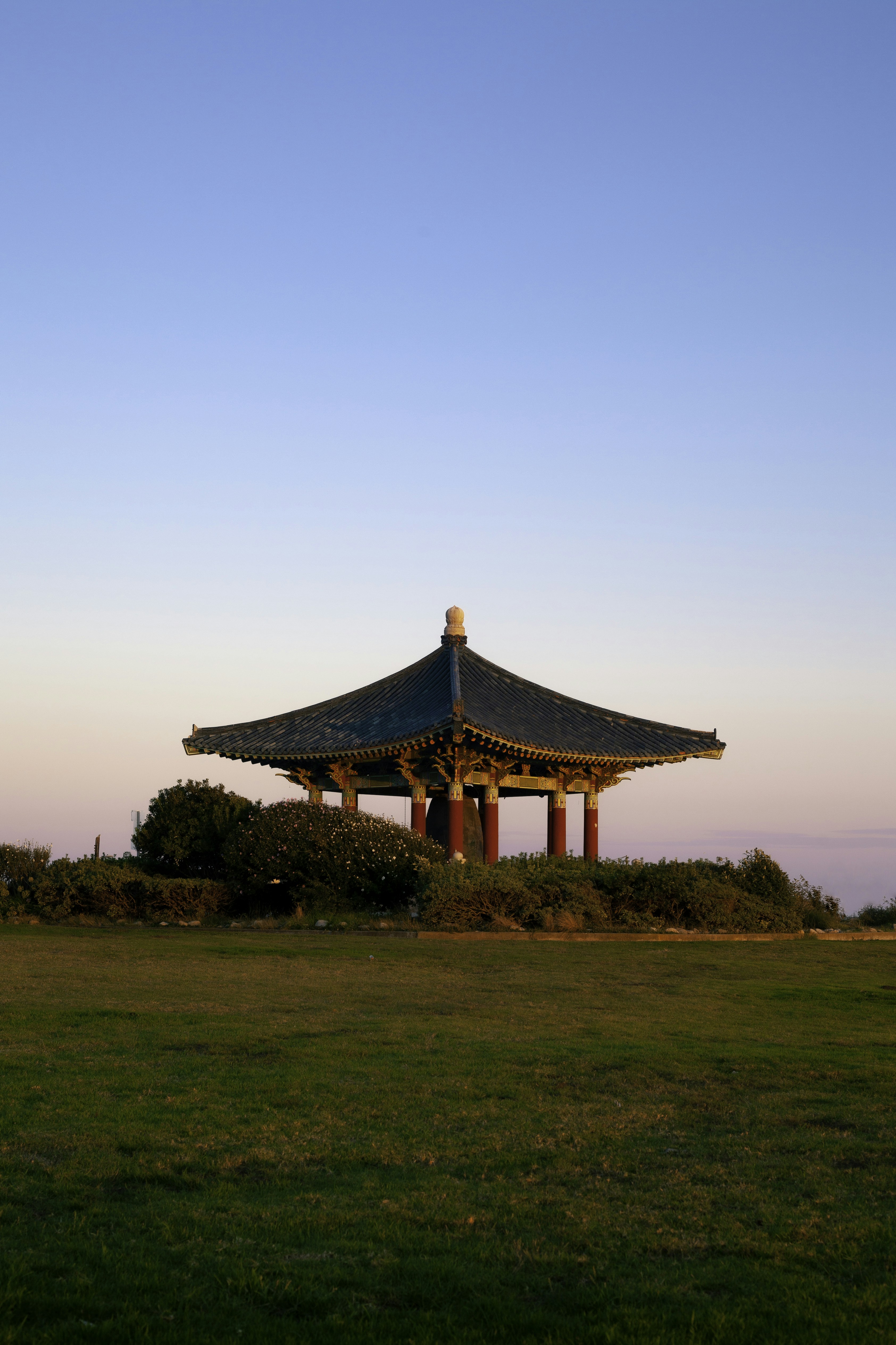 Casa de madera marrón y blanca en campo de hierba verde bajo cielo azul durante el día