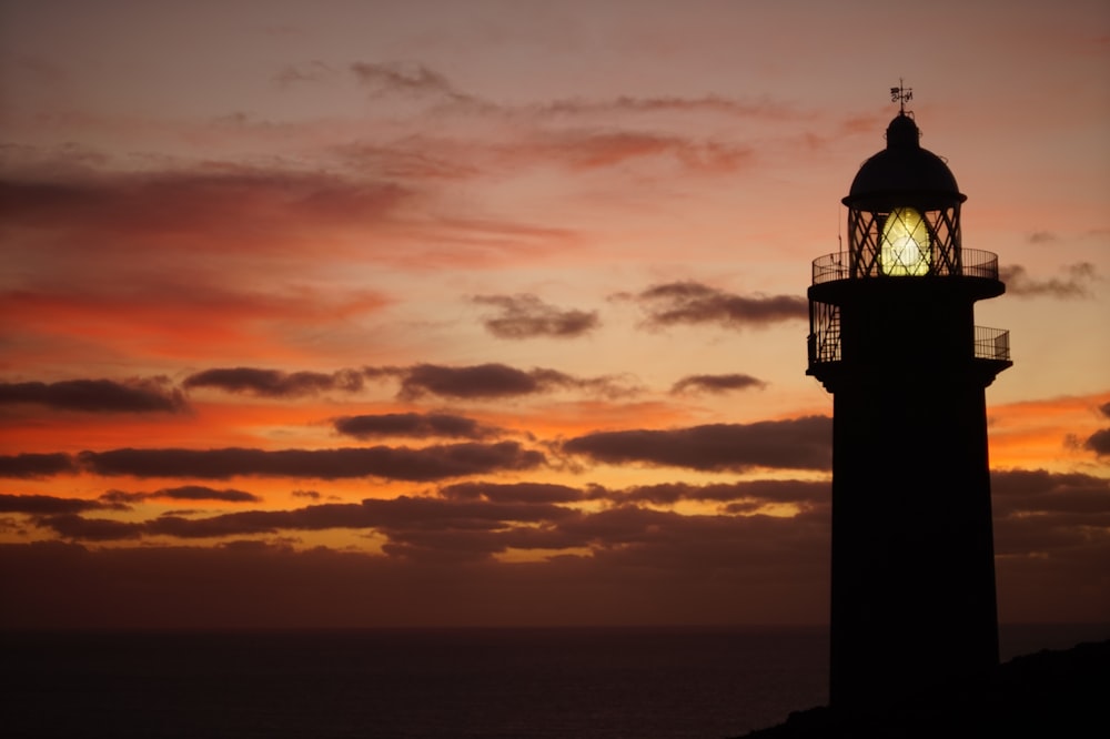 silhueta do farol durante o pôr do sol