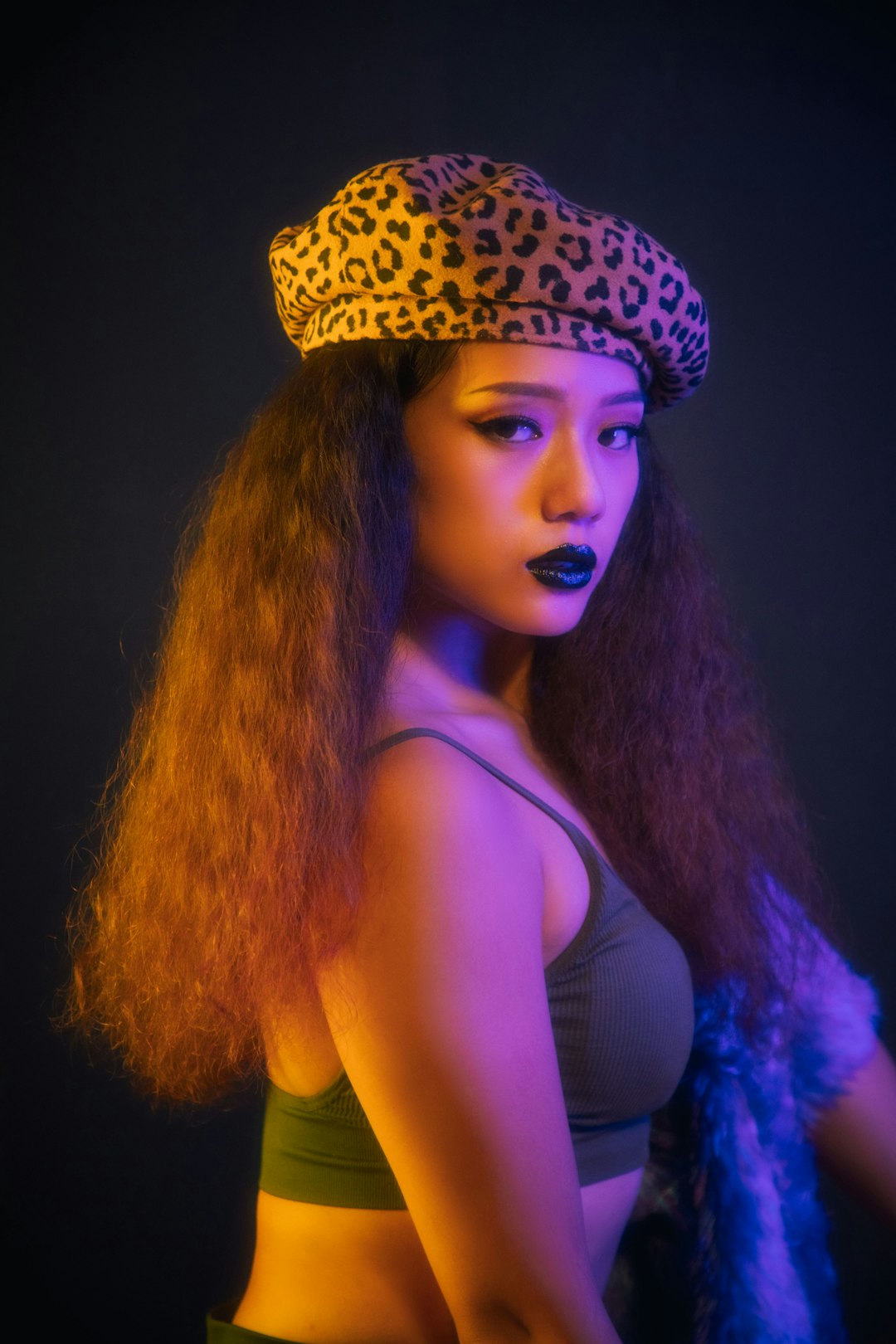 woman in black tank top wearing white and black leopard print hat