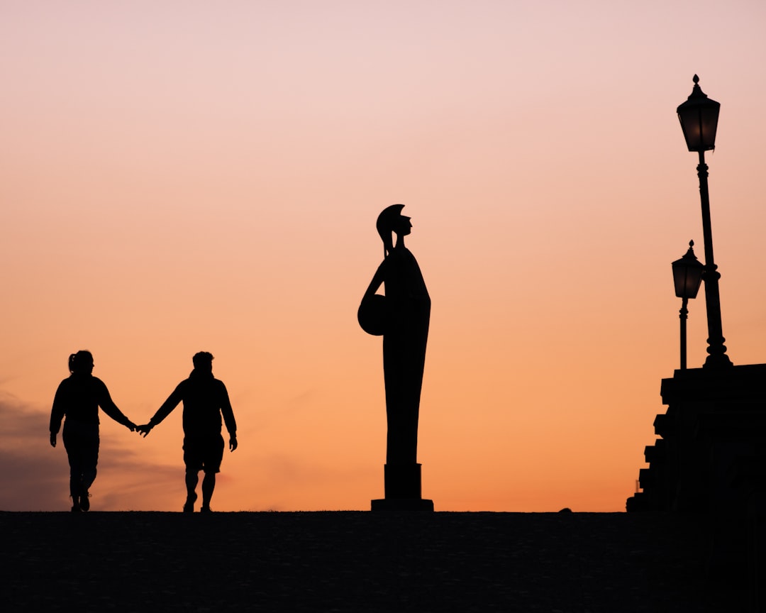 silhouette of people walking on the beach during sunset