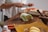 Man happily preparing a nutritious meal with fresh ingredients on a wooden countertop.