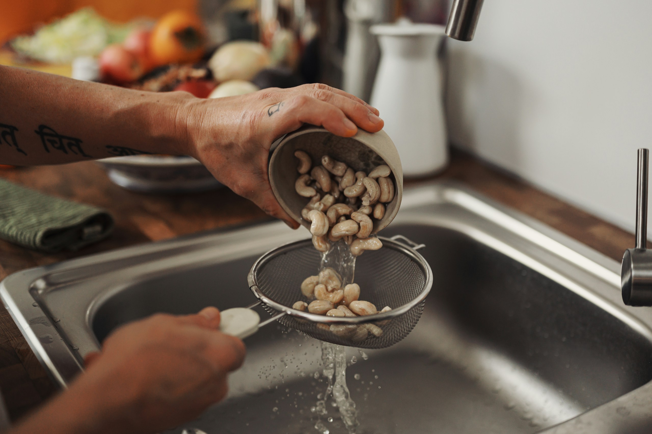 person holding stainless steel spoon with white and black beans