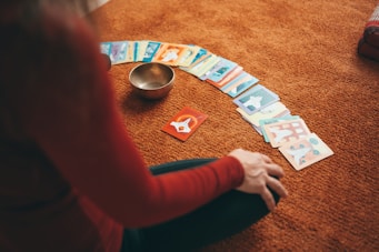 person in red long sleeve shirt holding playing cards