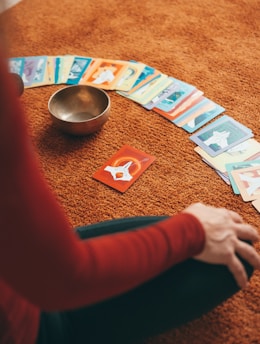 person in red long sleeve shirt holding playing cards