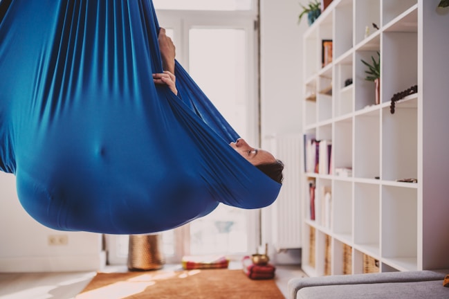 Hamak yoga practice showing a participant suspended in a hammock indoors
