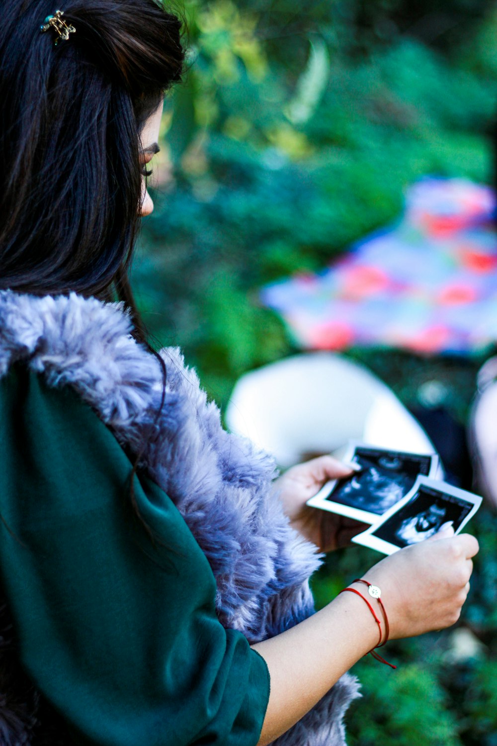 woman in green coat holding white and black camera