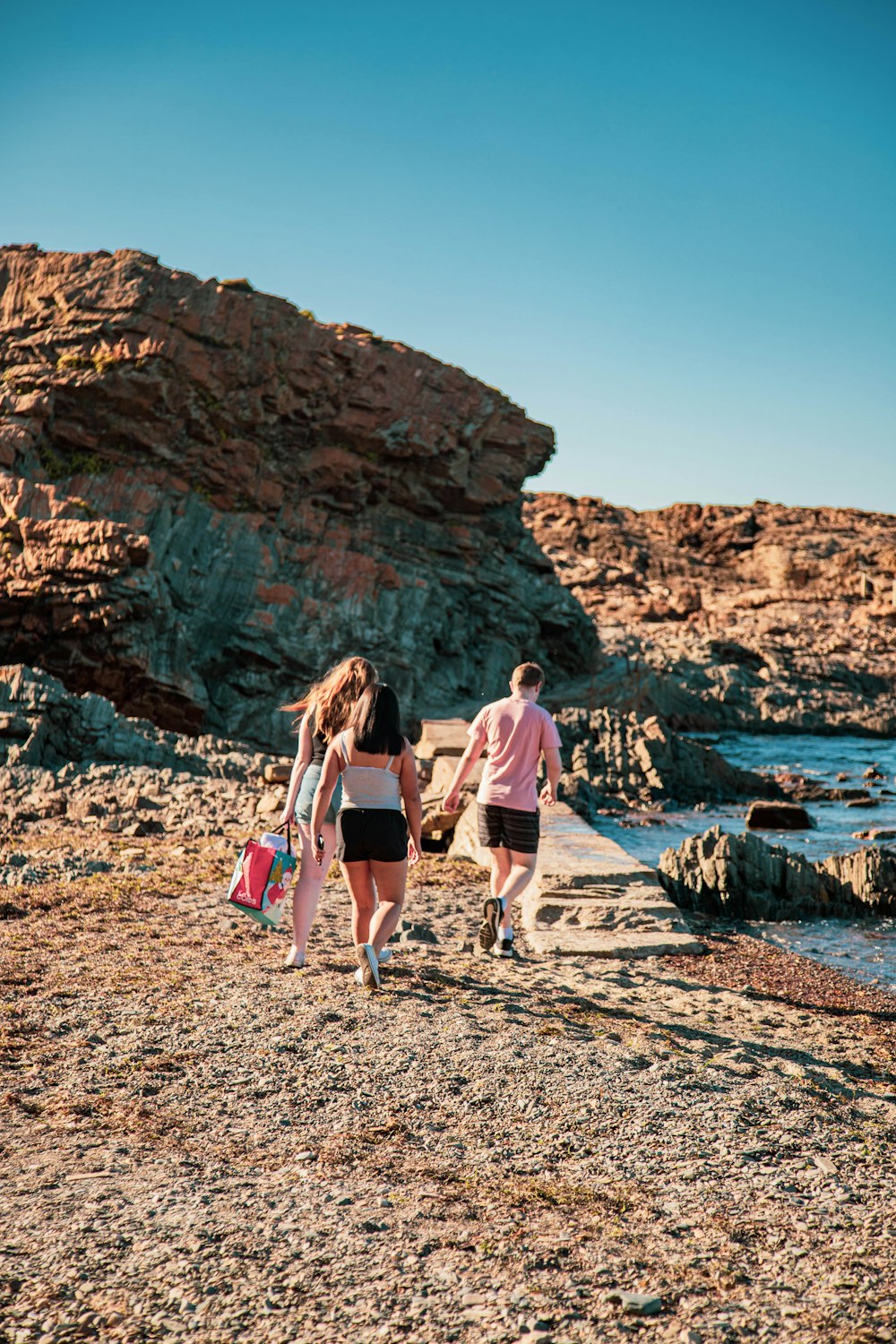 2 women walking on beach during daytime