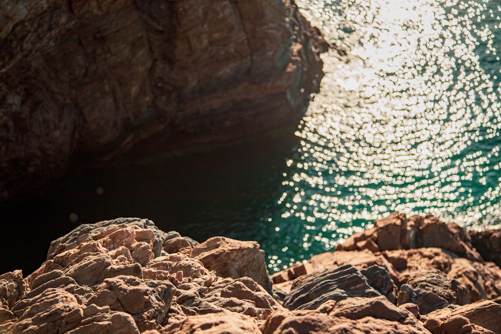 brown rock formation beside body of water during daytime