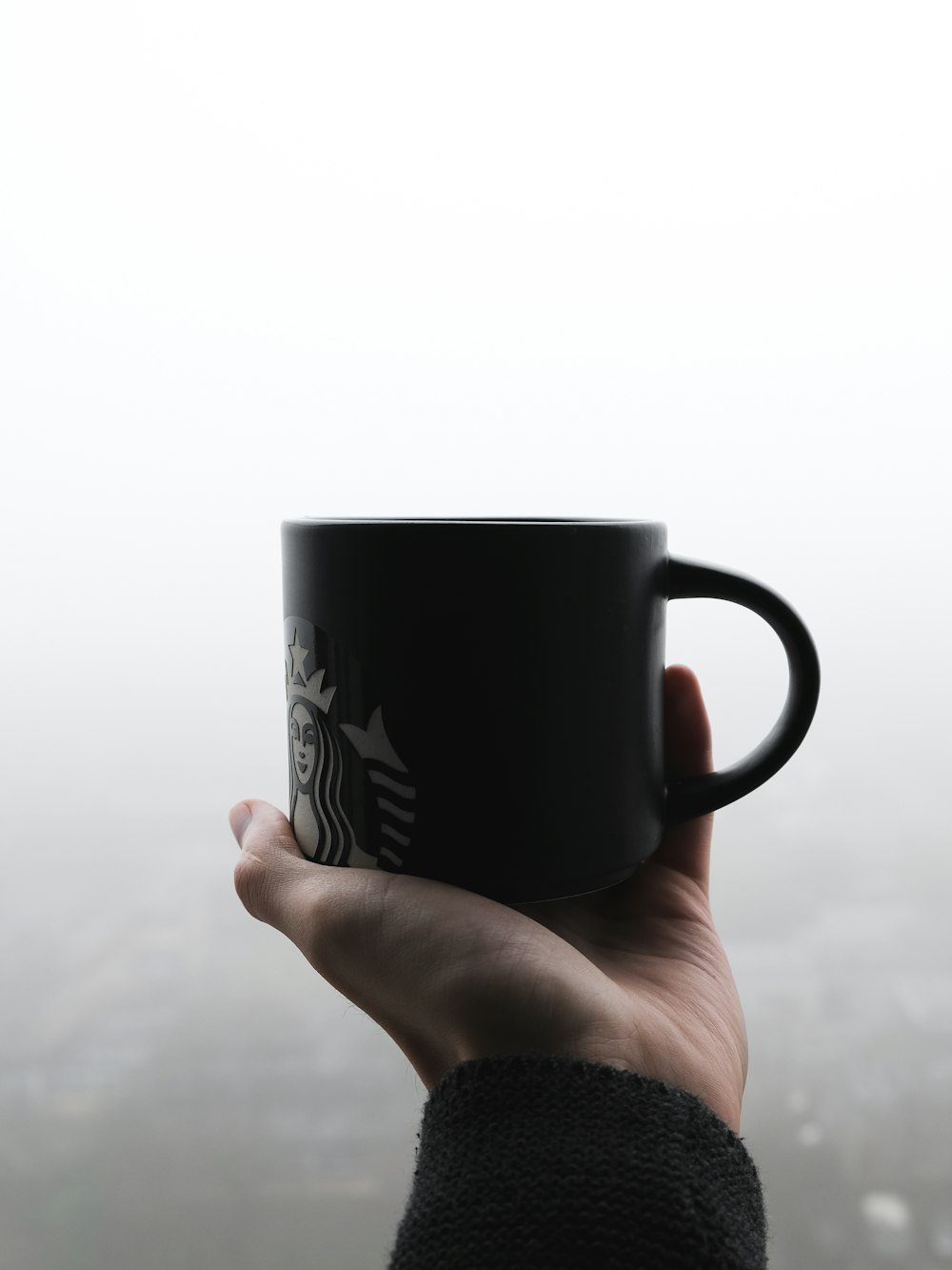 person holding black ceramic mug