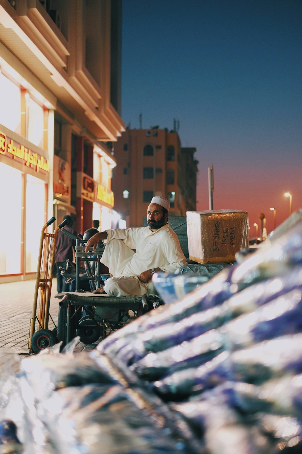 a man sitting on a bench next to a pile of luggage