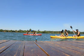 people riding on red kayak on sea during daytime