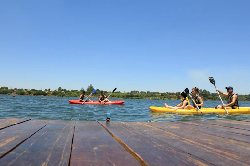 people riding on red kayak on sea during daytime