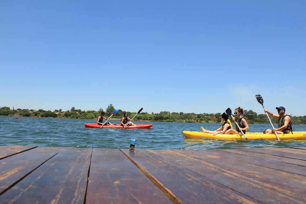 people riding on red kayak on sea during daytime