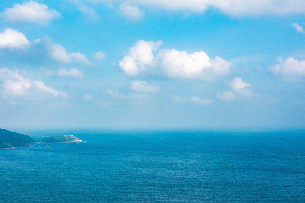 Bateau blanc sur la mer sous le ciel bleu et les nuages blancs pendant la journée