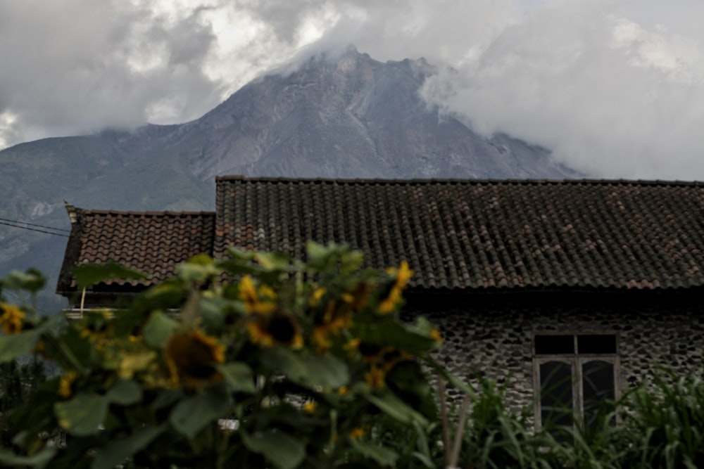 Casa marrone e bianca vicino alla montagna sotto le nuvole bianche durante il giorno