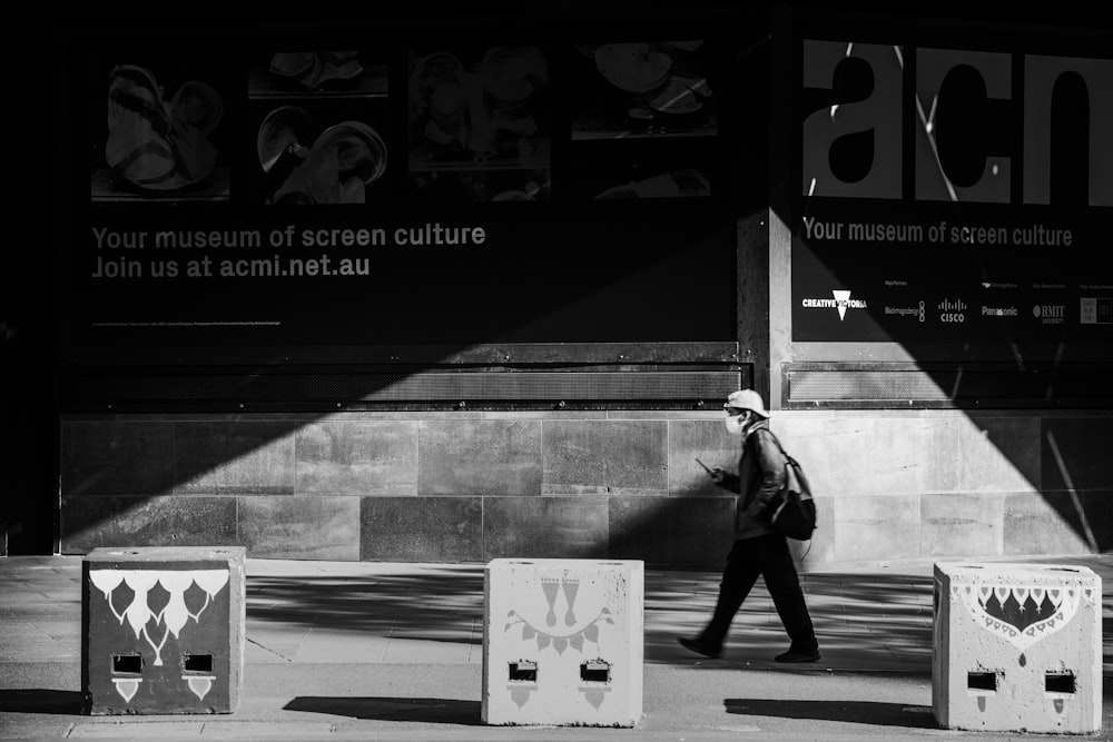 man in black jacket walking on sidewalk