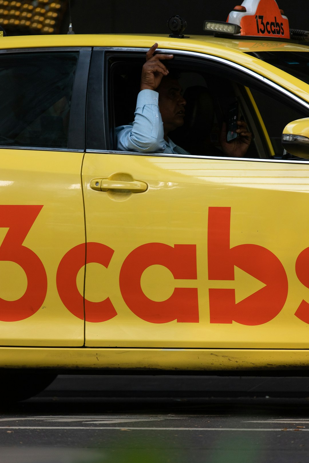 man in white t-shirt sitting on yellow car