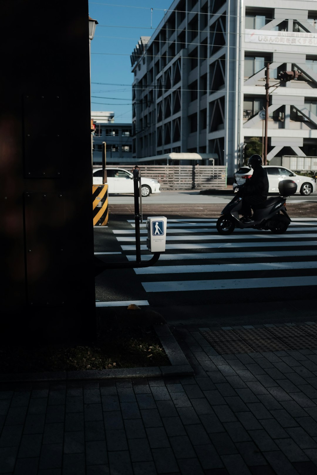 man in black jacket sitting on sidewalk during daytime