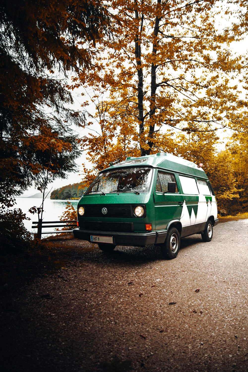 green and white volkswagen t-2 parked on the side of the road