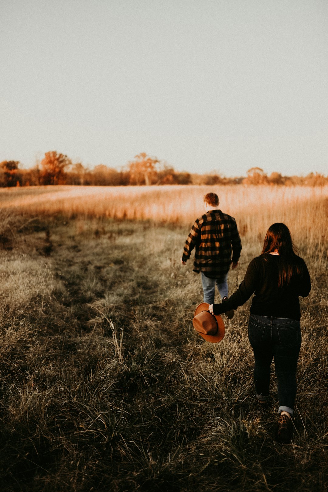 man and woman standing on grass field during daytime