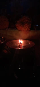 Close-up of a candle flickering softly beside meaningful decor pieces.