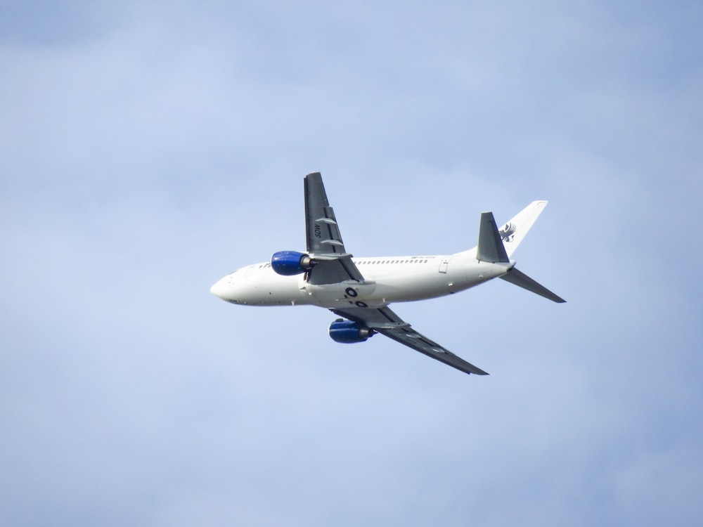 white and blue airplane in the sky