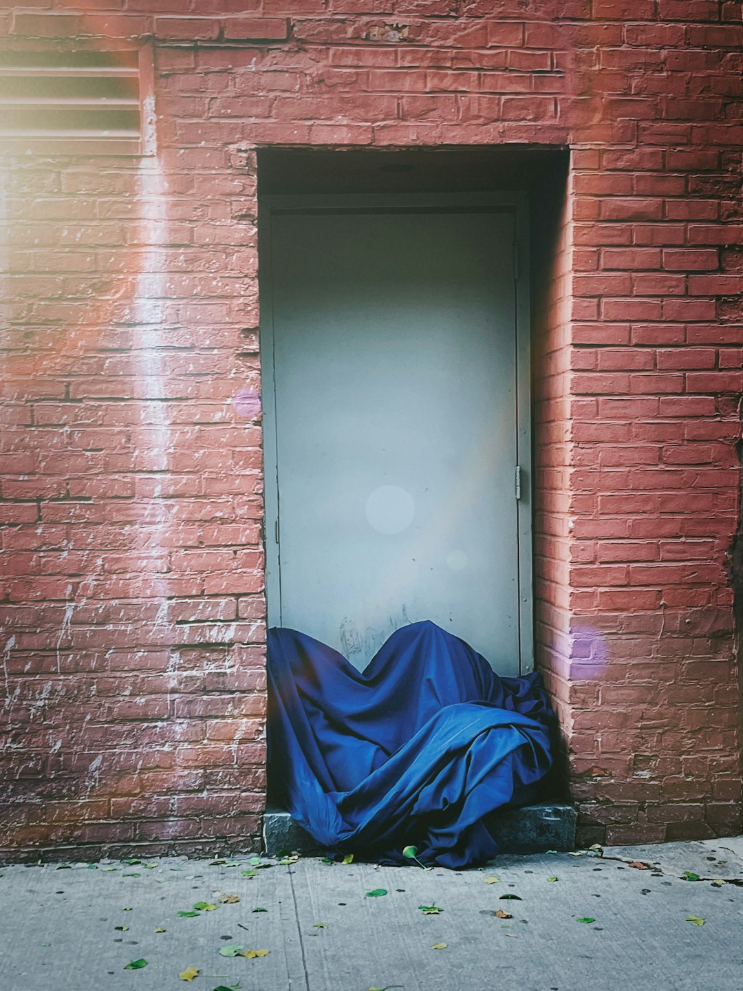 blue textile on blue textile beside brown brick wall