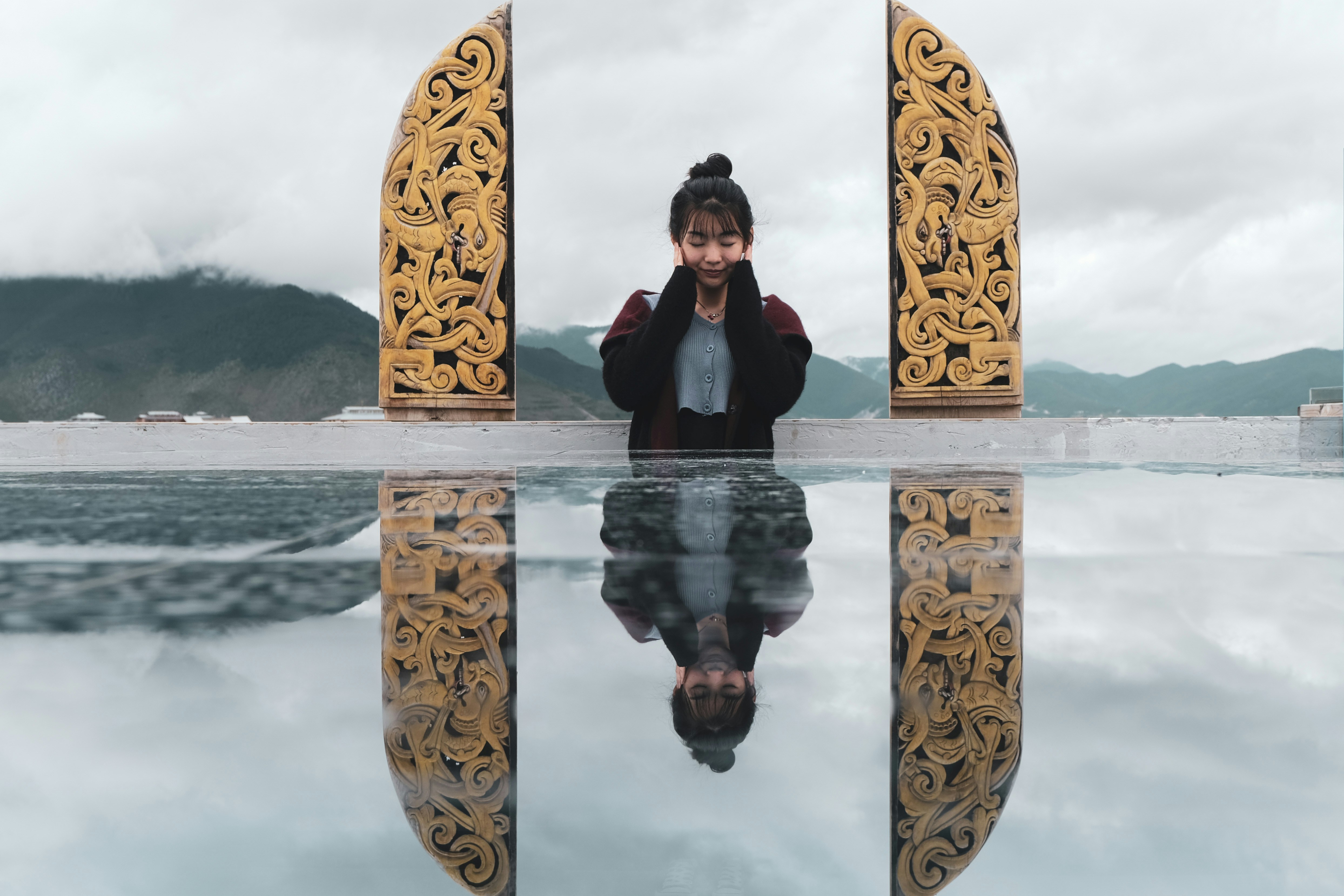 woman in red shirt sitting on water fountain
