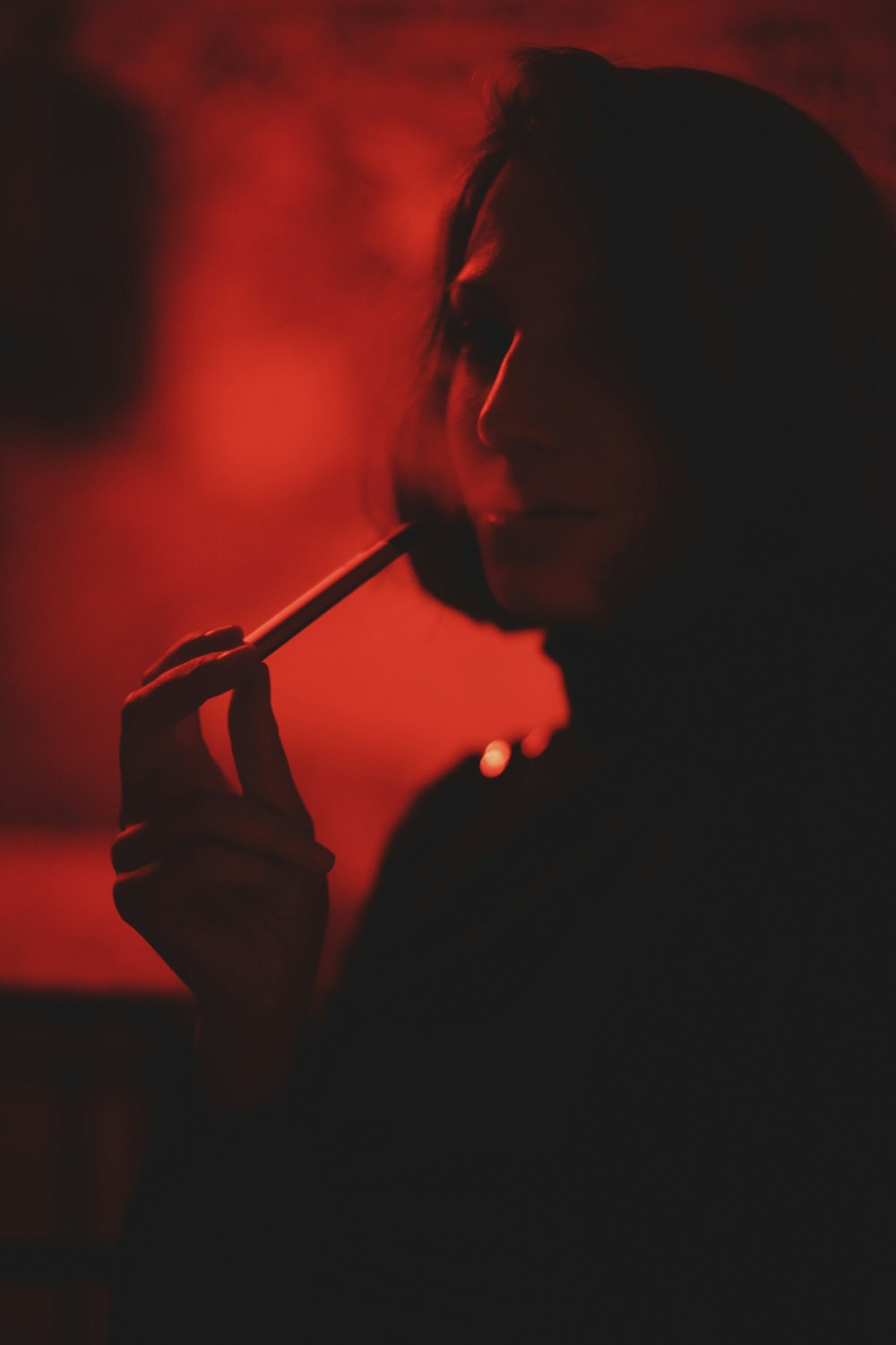 woman smoking cigarette in dark room