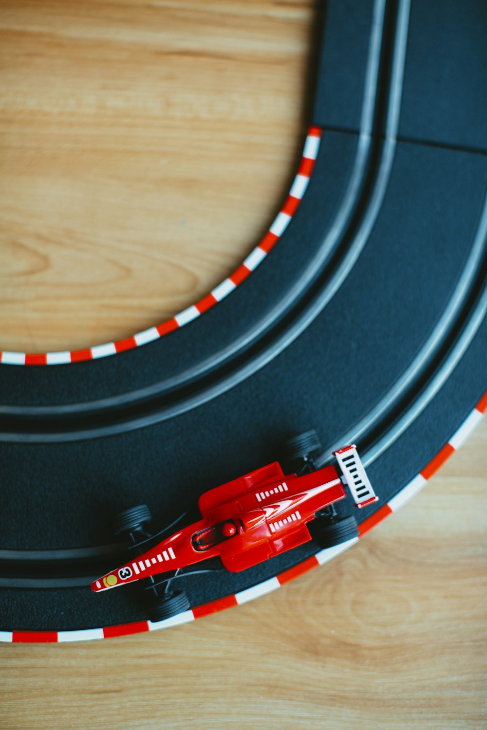 a toy race track with a red race car on it
