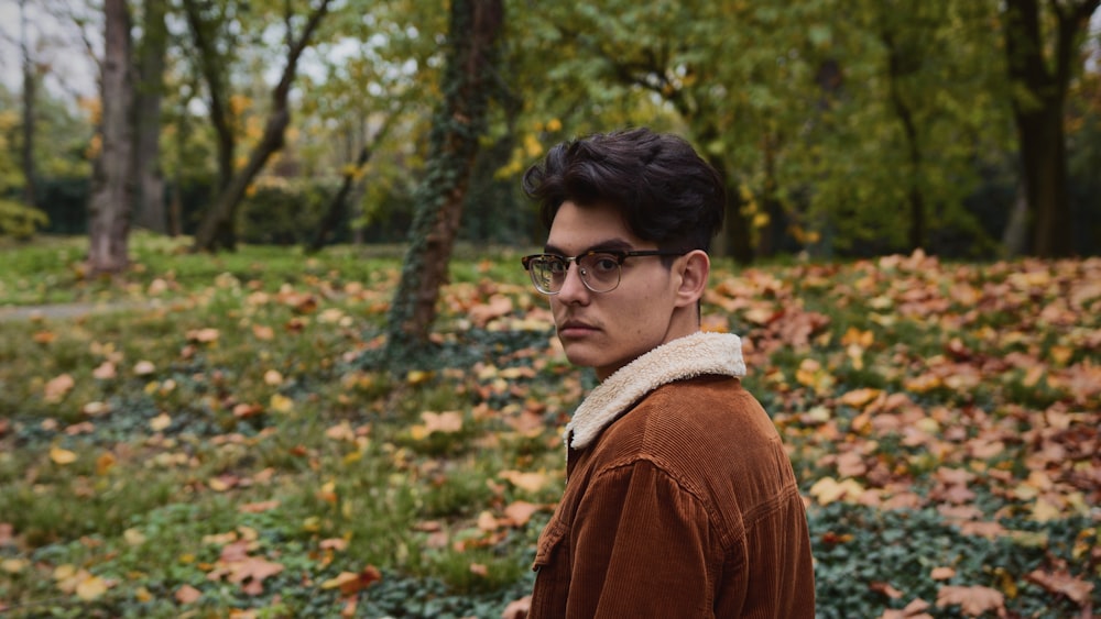 man in brown jacket wearing black framed eyeglasses