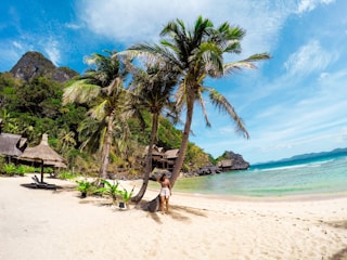 woman in black bikini walking on beach during daytime