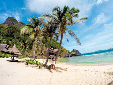 woman in black bikini walking on beach during daytime