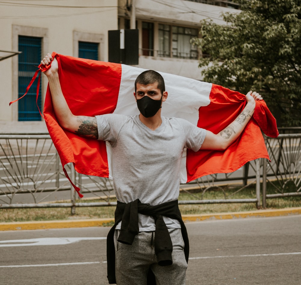 man in gray sweater holding red flag