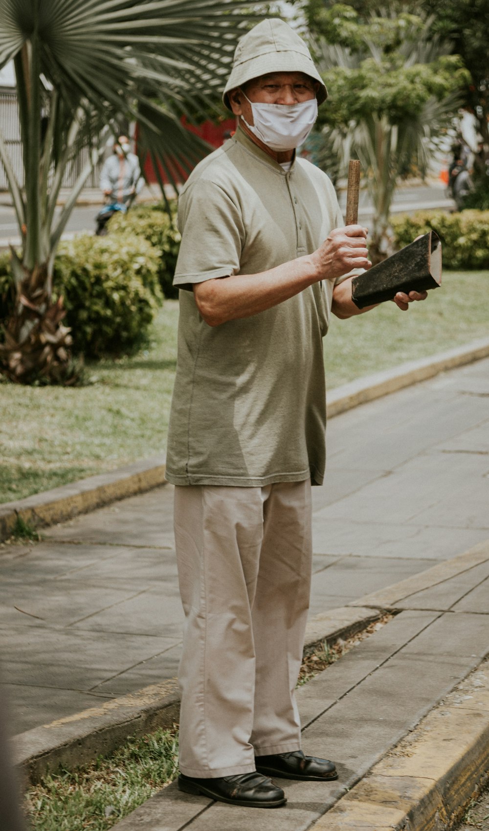 man in gray t-shirt and beige pants holding black and white book