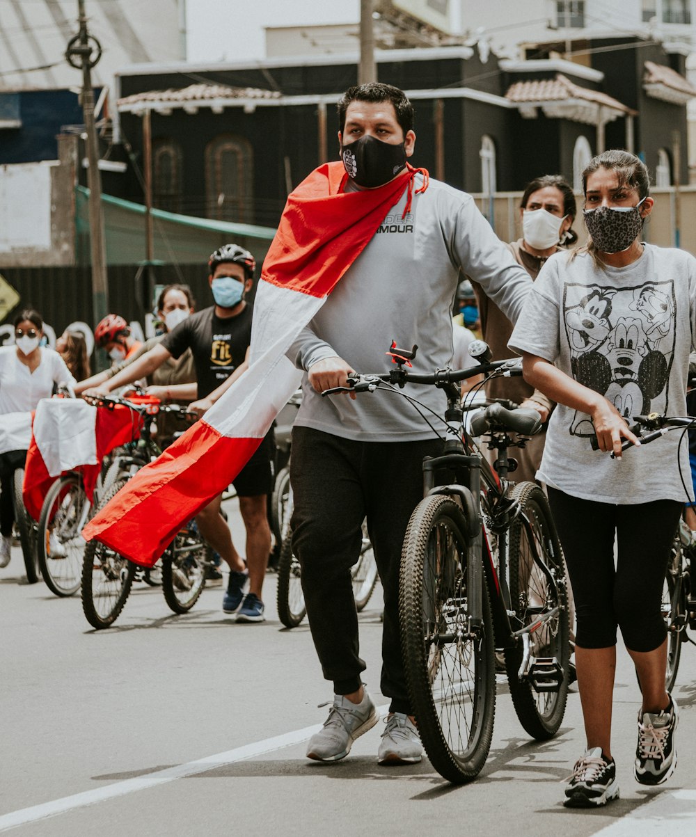 people in white shirts and black shorts riding on bicycle during daytime