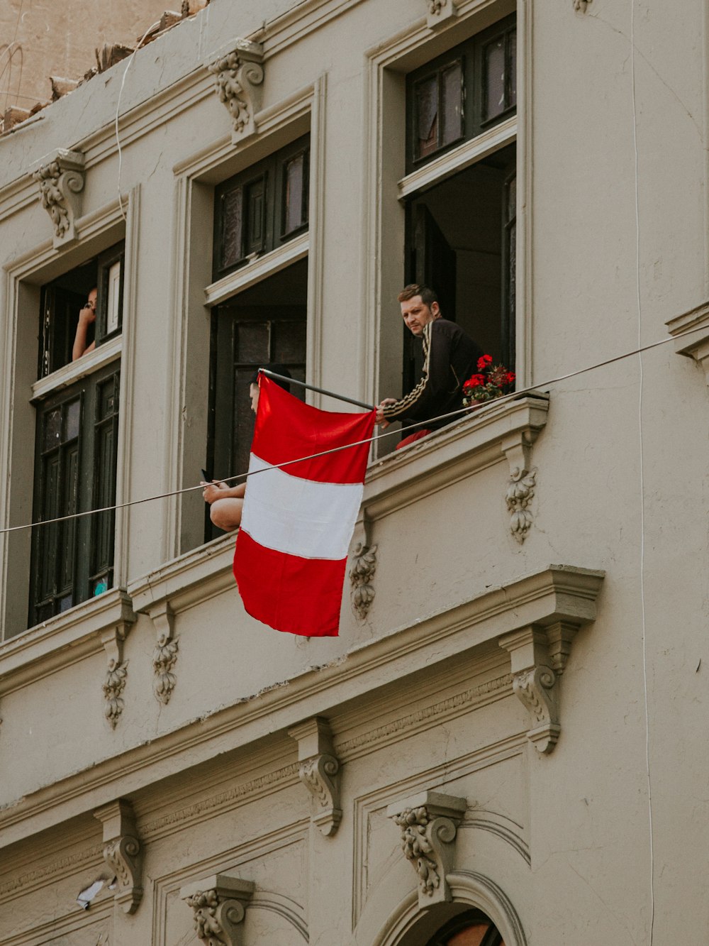 woman in black jacket and black pants holding red and white flag