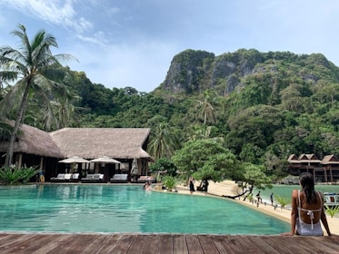 people walking on beach near green mountain during daytime BY MG TURIZM