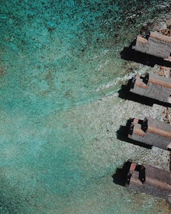 aerial view of brown concrete building beside body of water during daytime