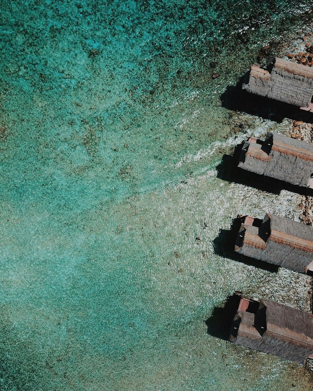 Vue aérienne d’un bâtiment en béton brun à côté d’un plan d’eau pendant la journée