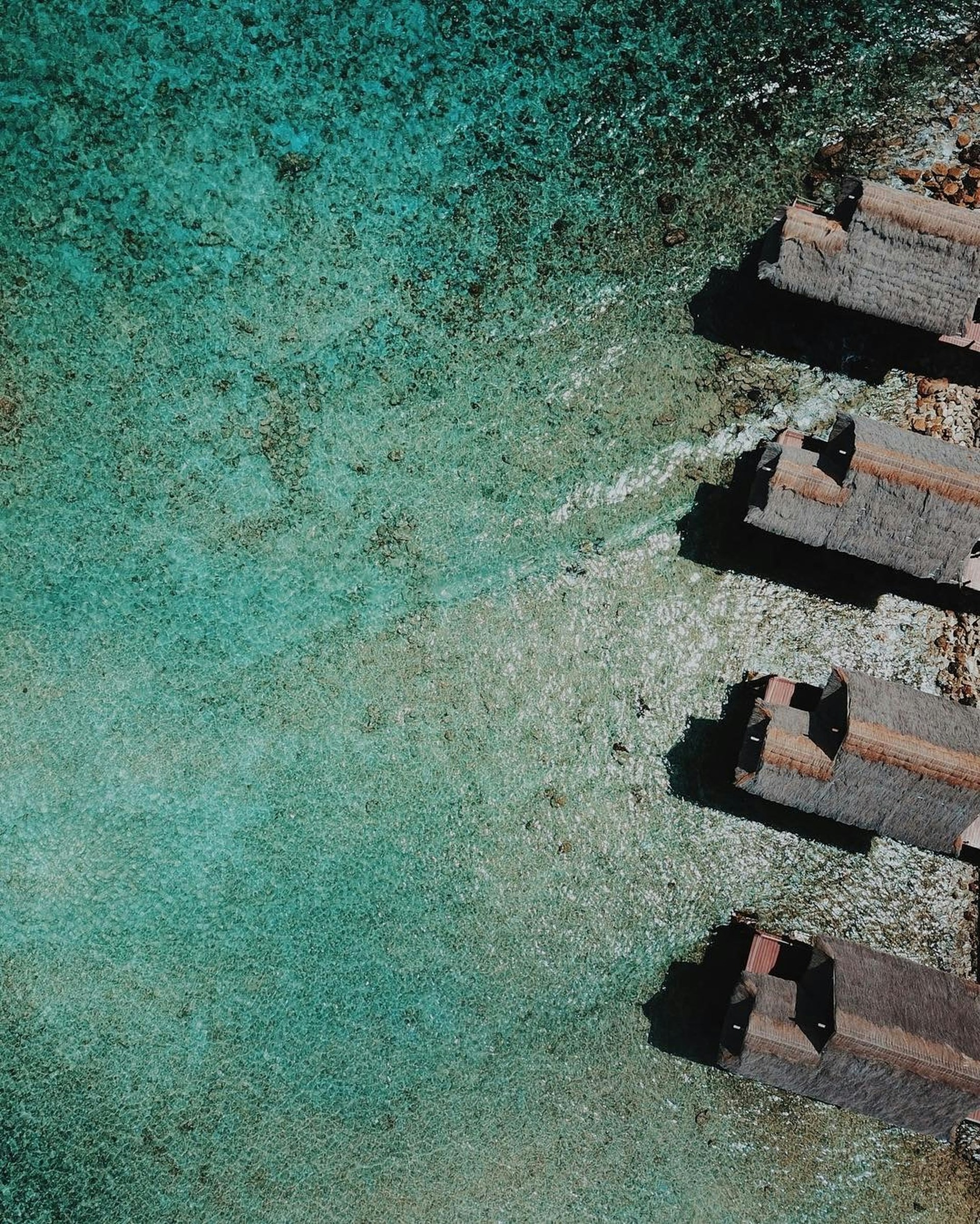 aerial view of brown concrete building beside body of water during daytime