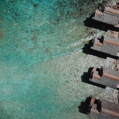 aerial view of brown concrete building beside body of water during daytime