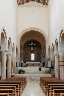 A serene image of a peaceful church interior with soft lighting and wooden pews.
