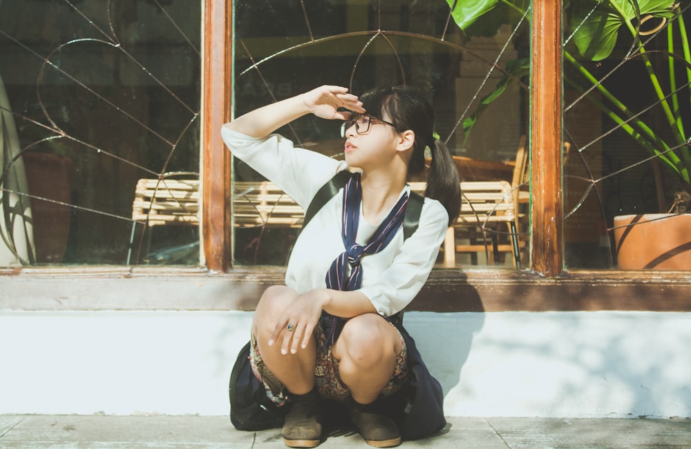 woman in white dress shirt and black skirt sitting on white floor