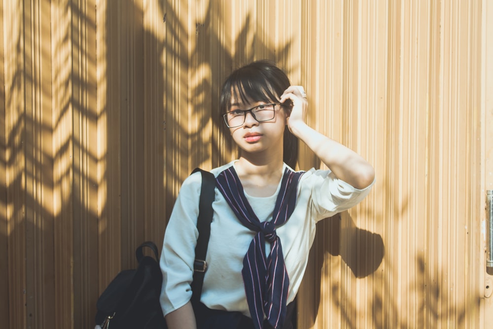 Donna in uniforme scolastica bianca e blu che indossa occhiali da vista con montatura nera